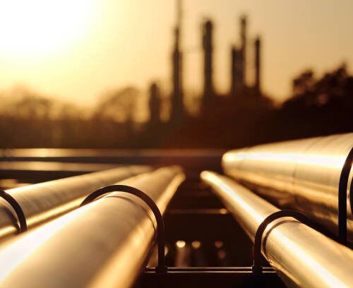 golden sunset in crude oil refinery with pipeline system